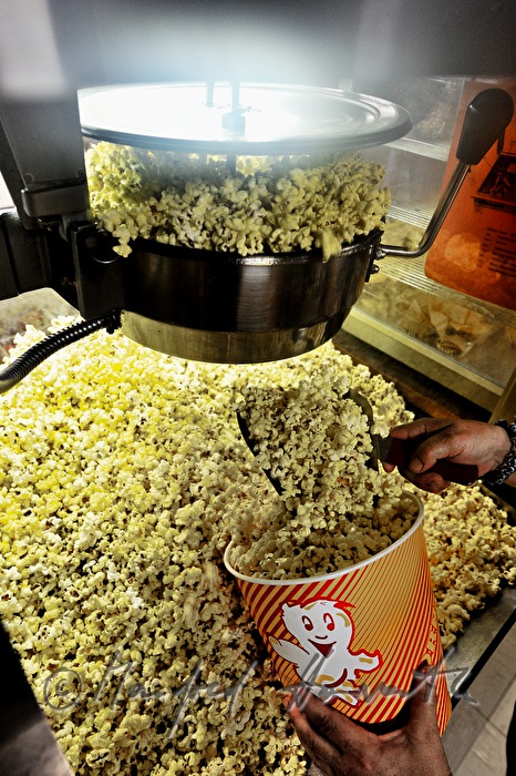 Popcorn Einfüllen in Becher im Kino-Buffet