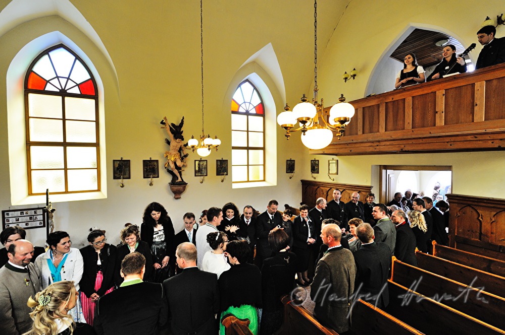 Hochzeitsgesellschaft und Brautpaar beim Altar nach der  Zeremonie