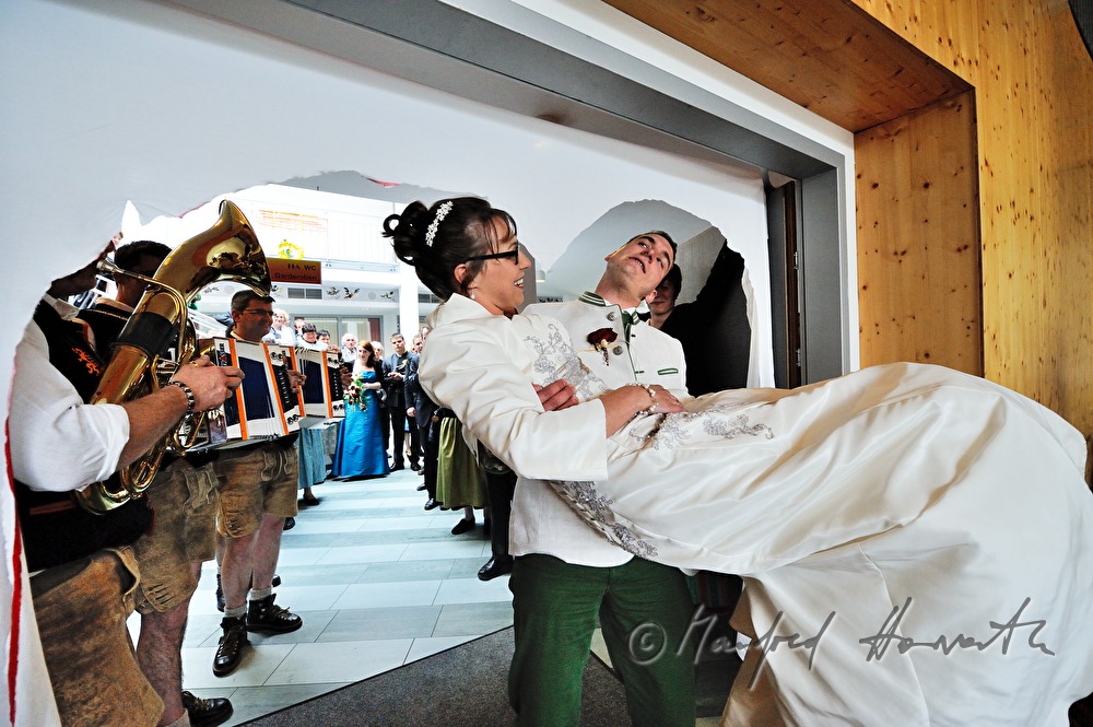Bräutigam trägt die Braut in den Speisesaal