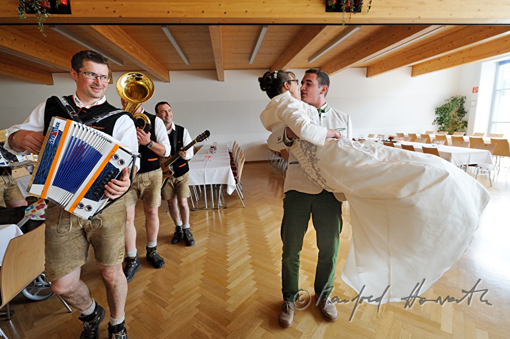 Bräutigam trägt die Braut in den Speisesaal