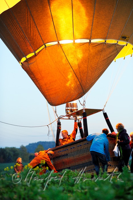 Passanten helfen bei der Landung des Ballons auf einem Feldweg