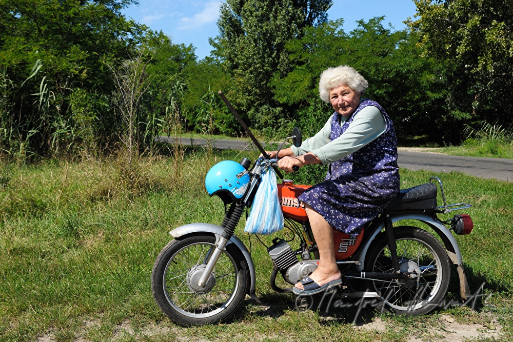 Bäuerin fährt mit dem Moped einkaufen