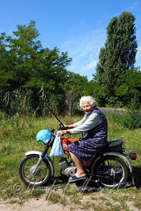 Bäuerin fährt mit dem Moped einkaufen