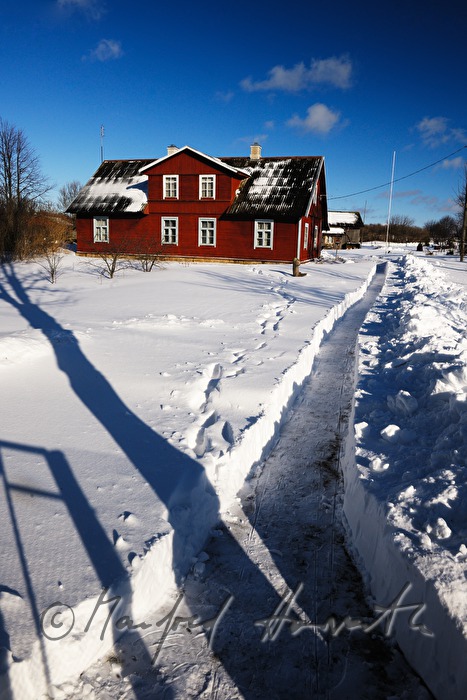 Holzhaus in Schwedenrot und Schneeweg