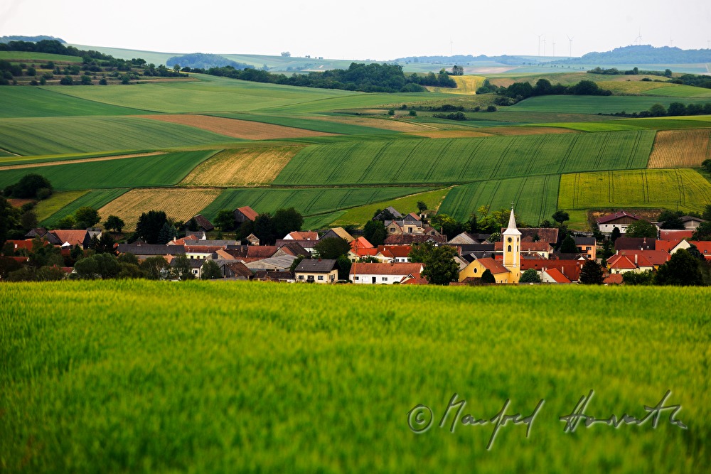 rollende Landschaft mit dem Dorf in der Mitte