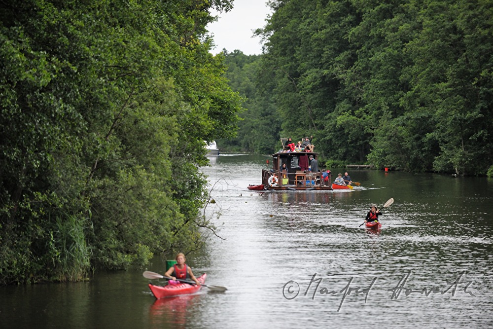Kajakfahrer und Hausboot fahren in der Nähe von Malchow