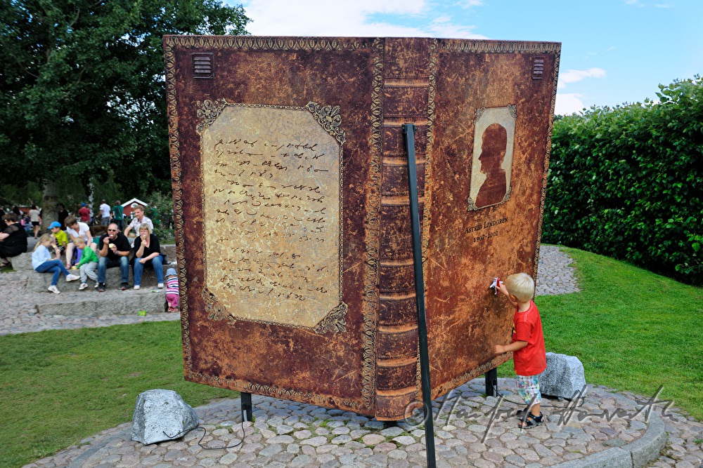 Kind spielt beim Astrid Lindgren Denkmal (Riesenbuch)