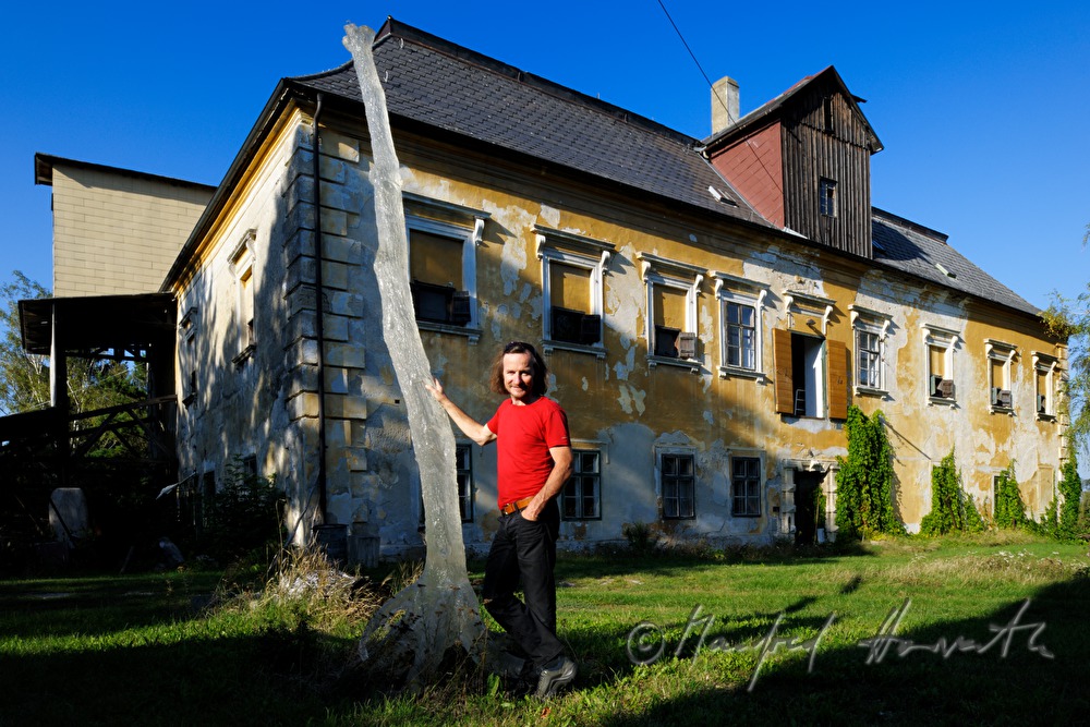 Johann Feilacher mit Baum-Skulptur vor dem Atelier