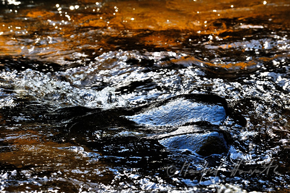 wasserumspülte Granitfindlinge im Flusslauf