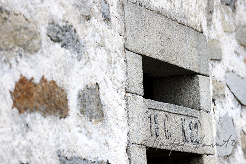 schlitzförmiges Fenster eines Kuhstalles in Steinblass-Bauweise