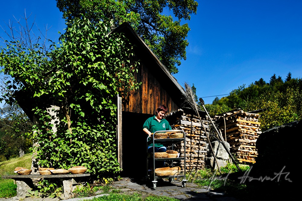 Backen von Holzofenbrot im feuerbetriebenen Backhaus