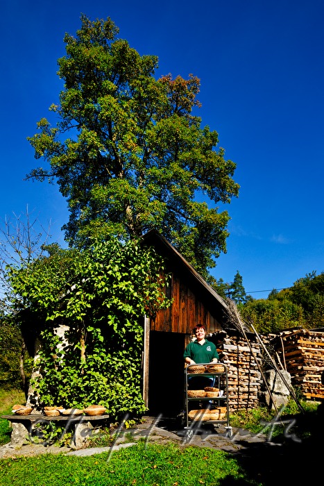 Backen von Holzofenbrot im feuerbetriebenen Backhaus