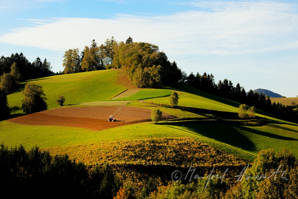 Traktor in einem Feld auf einem Hügel