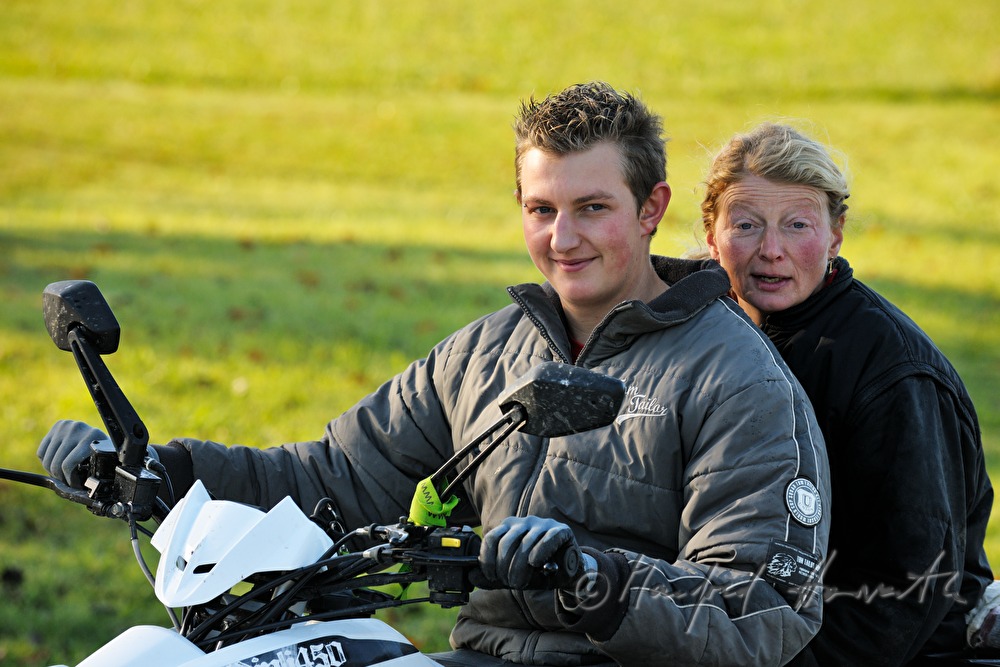 Bäuerin und Sohn auf ATV auf der Weide