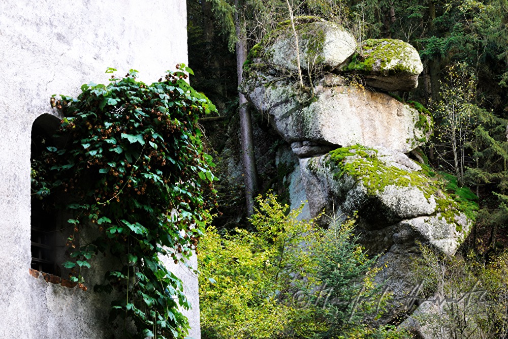 verwitterter Granitfelsen und Fenster einer Mühle