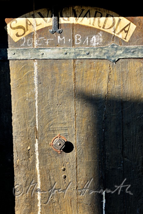 Holztür mit lateinischer Aufschrift im Mauthaus