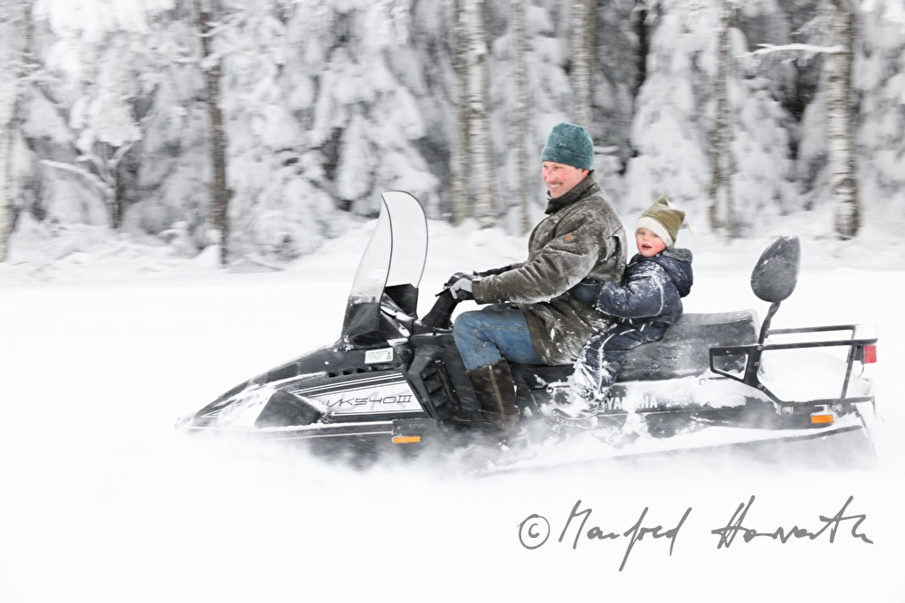Vater mit Sohn unterwegs mit dem Motorschlitten