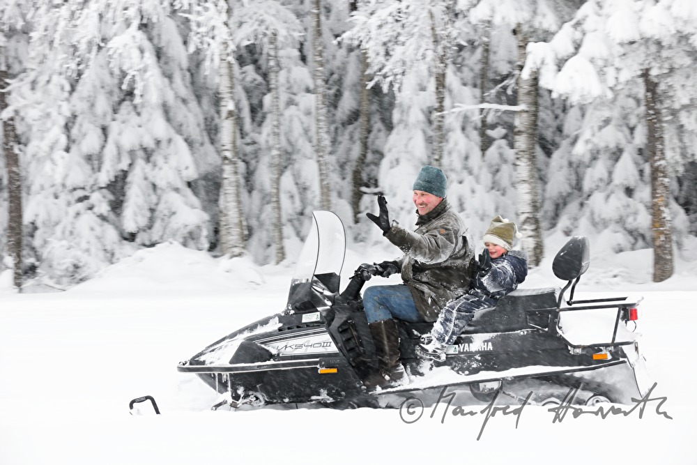 Vater mit Sohn unterwegs mit dem Motorschlitten