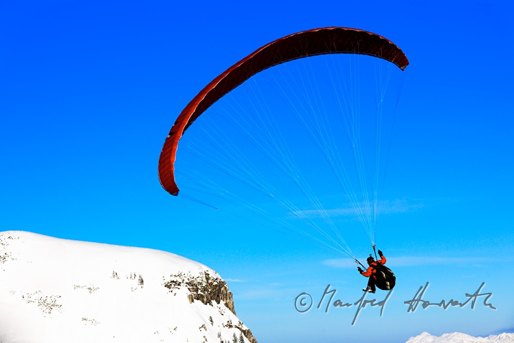 Gleitschirmflieger beim Flug in das Tal