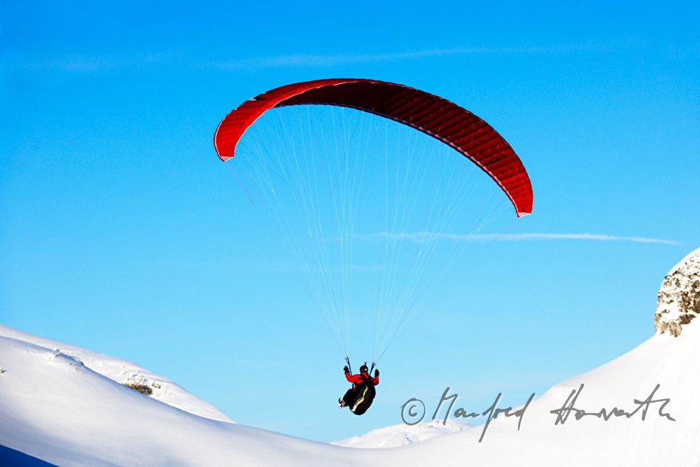 Gleitschirmflieger beim Flug in das Tal