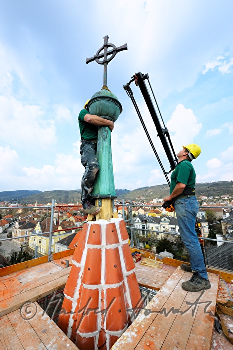 Spengler setzen den Spitz auf den Kirchturm