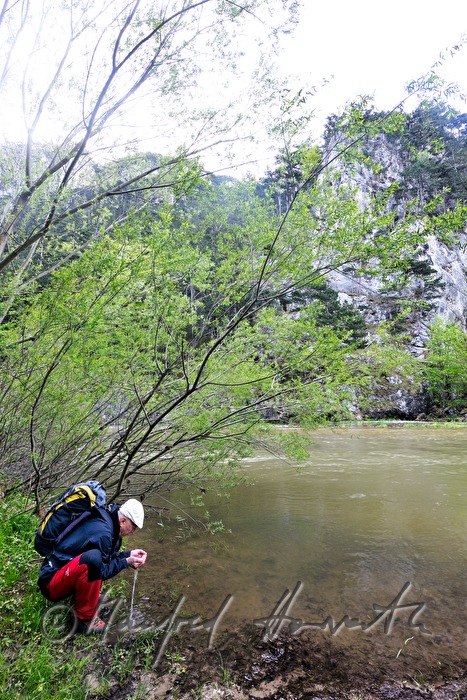 Wanderer auf dem Weg zur Rax trinkt aus dem Fluss