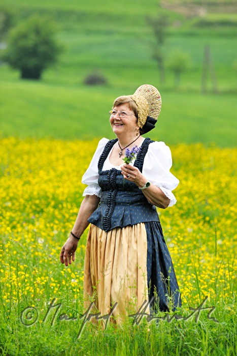 Frau in Wachauer Tracht beim Blumenpflücken