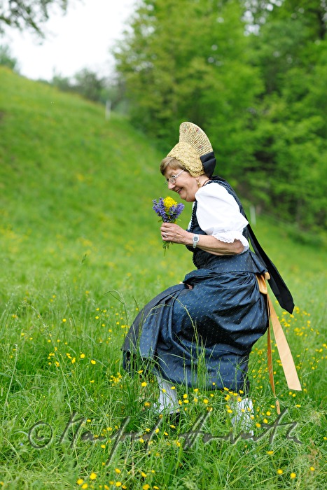 Frau in Wachauer Tracht beim Blumenpflücken