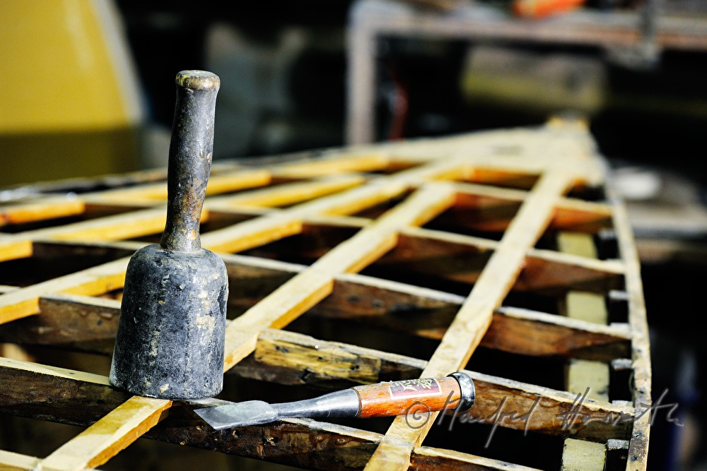 Hammer und Stemmeisen auf den Spanten einer Rennjolle aus Holz