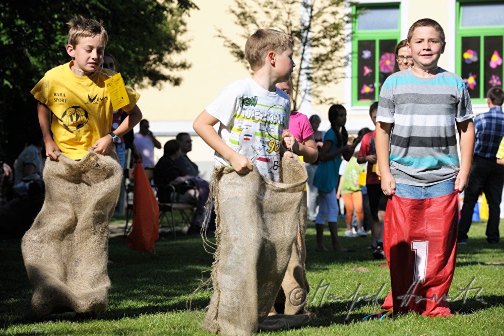 Kinder beim Sackhüpfen im Schulhof