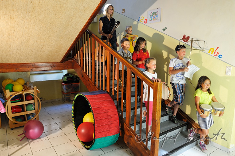 Schüler und Lehrerin auf der Treppe mit Musikinstrumenten