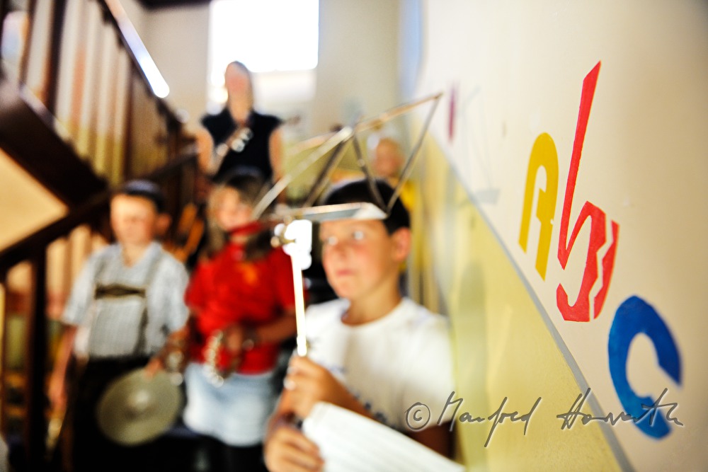 Schüler und Lehrerin auf der Treppe mit Musikinstrumenten