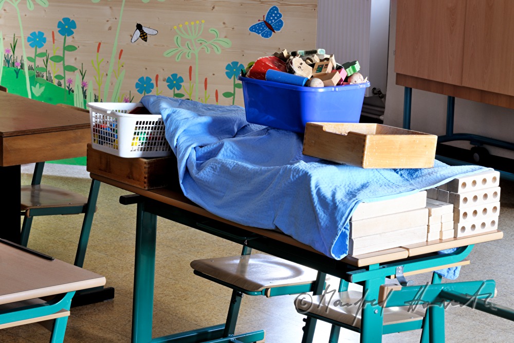 zugedecktes Spielzeug auf einer Schulbank während der Sommerferien