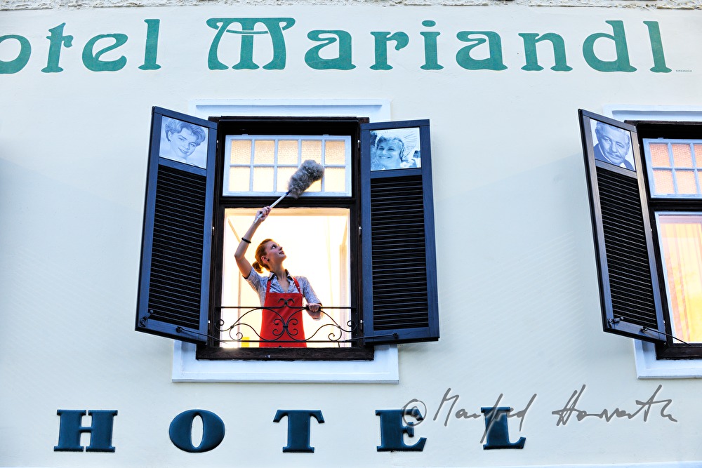 Putzfrau des Hotel Mariandl mit Mop am Fenster