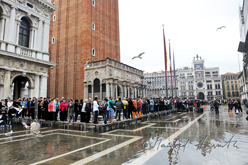 Touristen auf dem Markusplatz bei Hochwasser