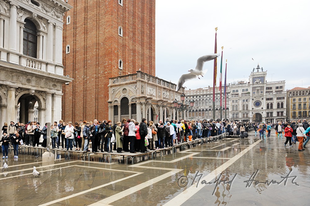Touristen auf dem Markusplatz bei Hochwasser