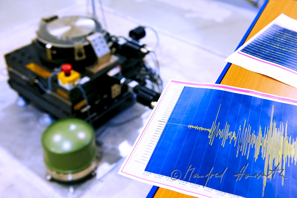 Seismometer (grün) und Seismogramm im Vordergrund  (Fukushima Katastrophe)