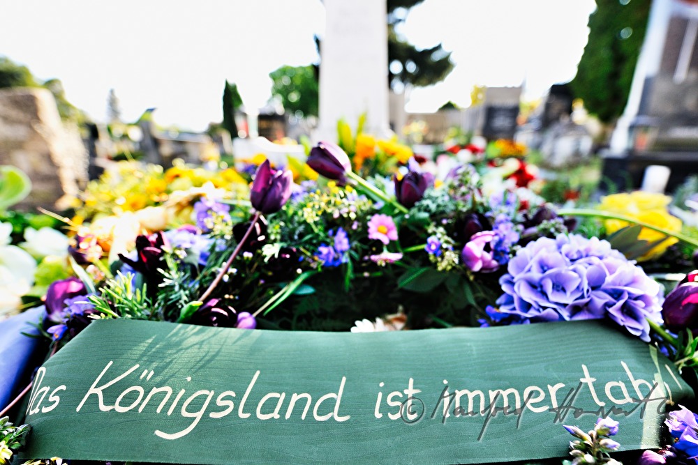 frisches Grab mit Kränzen und Blumenschmuck