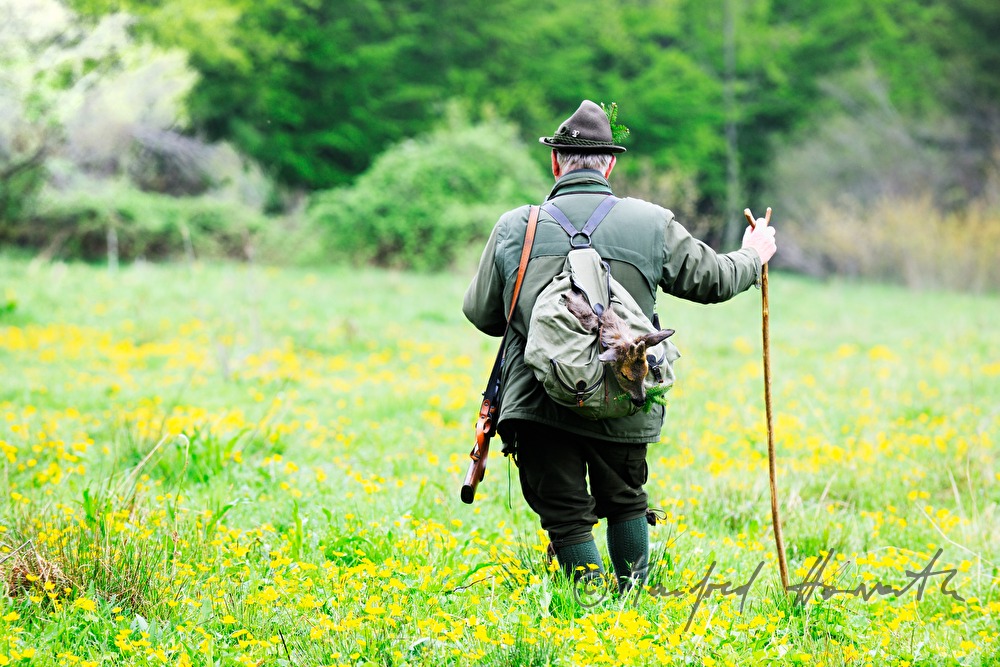 Jäger mit frisch erlegtem Reh im Rucksack