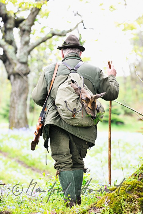 Jäger mit frisch erlegtem Reh im Rucksack