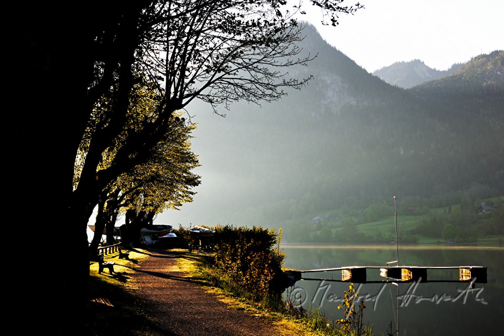 Uferpromenade mit Sitzbänken und Segelboot