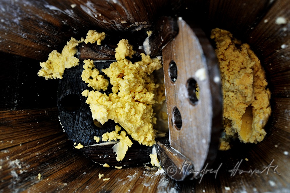 Senner rührt Butter im Butterfass
