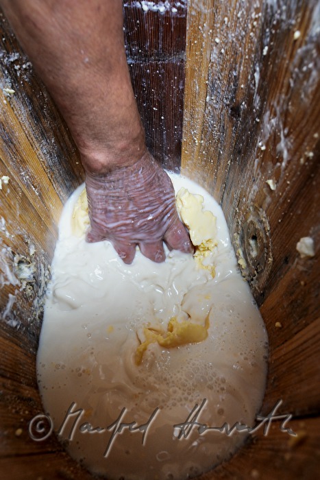 Senner rührt Butter im Butterfass