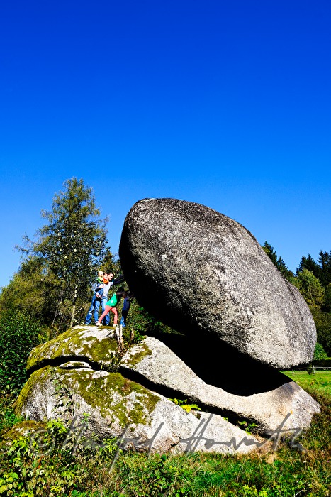 Familie versucht den Granitblock zu bewegen