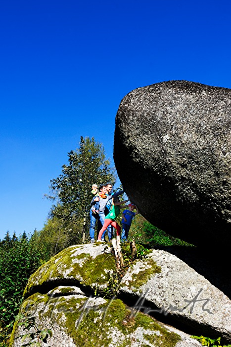 Familie versucht den Granitblock zu bewegen