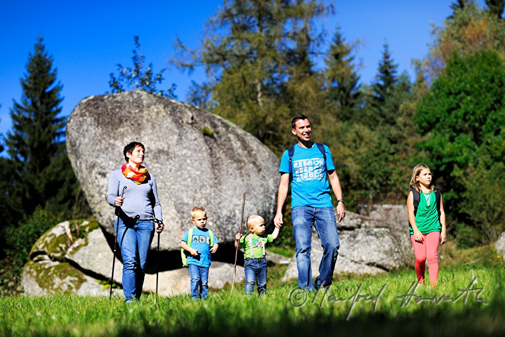 Familie wandert am Granitblock vorbei