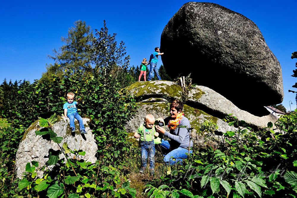 Familie versucht den Granitblock zu bewegen