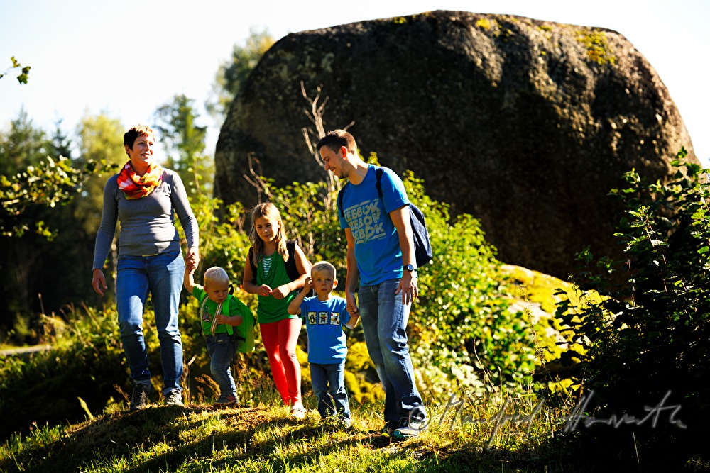 Familie wandert am Granitblock vorbei