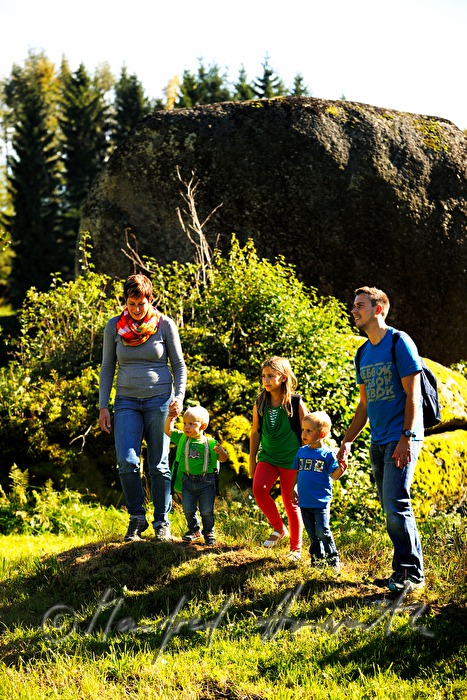 Familie wandert am Granitblock vorbei