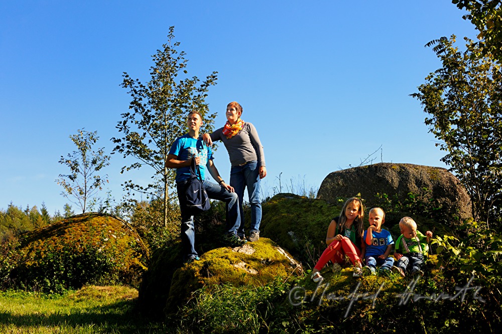 Familie macht eine Pause beim Granitblock